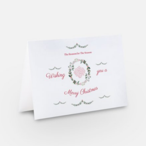 Front of a Christmas greeting card with a wreath graphic in a white background and Isa 9:6 in the center.