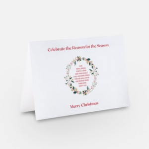 Front of a Christmas greeting card with a wreath graphic in a white background and Matt 1:21 in the center.